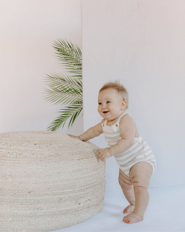 Baby wearing organic cotton stripe knit bubble bubble romper in mushroom stripes with magnetic closures at crotch.