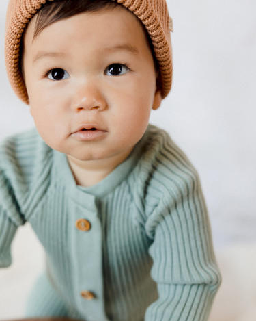 Photo shows baby boy wearing jade organic cotton knit romper with Magnetic Buttons.