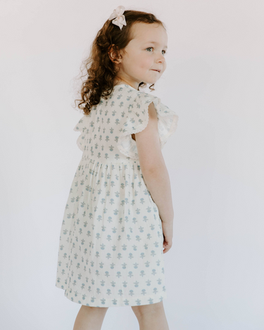 Little girl wearing cotton muslin flutter sleeve dress in cheerful floral