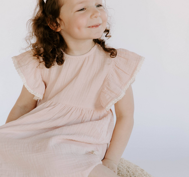 Little girl wearing cotton muslin flutter sleeve dress in orchid pink