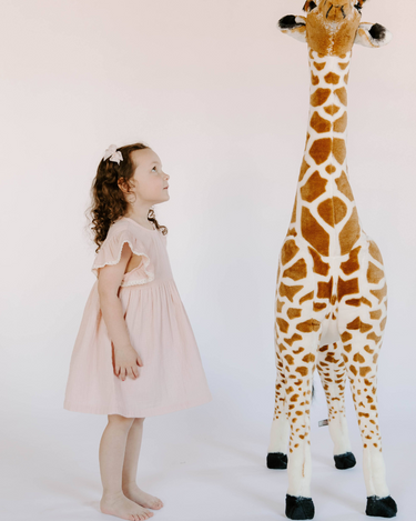 Little girl wearing cotton muslin flutter sleeve dress in orchid pink