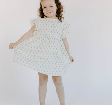 Little girl wearing cotton muslin flutter sleeve dress in cheerful floral 