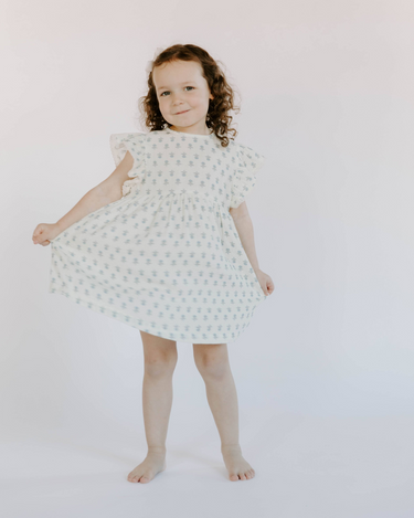 Little girl wearing cotton muslin flutter sleeve dress in cheerful floral 