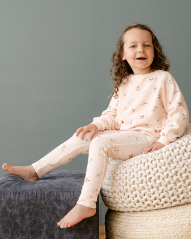 Image shows baby girl wearing organic cotton waffle leggings in bird print.