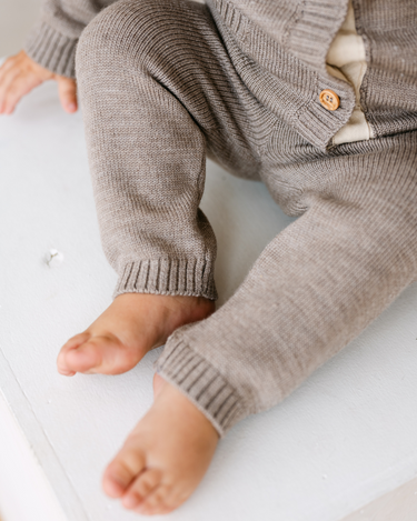 Image shows baby boy wearing merino wool baby gift set in heather brown.