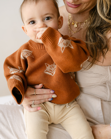 Image shows baby boy wearing organic cotton knit sweater with fox jacquard pattern in mocha.