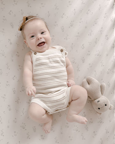 Image shows baby girl laying wearing organic cotton knit stripe romper in mushroom.