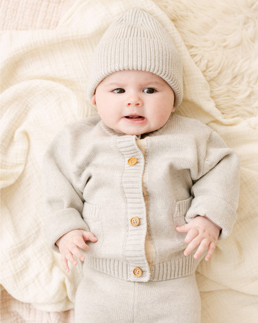 Image shows baby girl wearing merino wool baby gift set in light heather gray.
