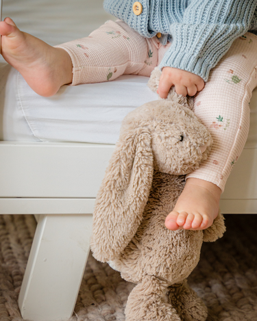 Image shows baby girl wearing organic cotton waffle leggings in bird print.