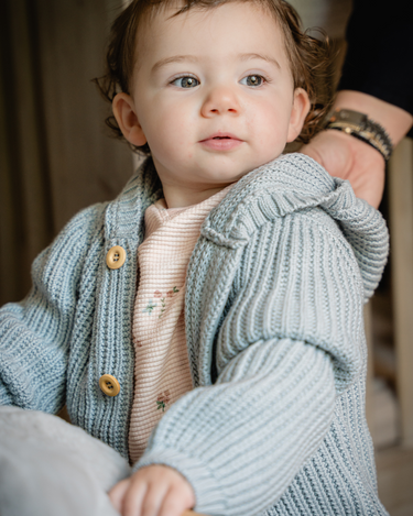 Image shows baby girl wearing pima cotton knit hoody in pearl blue.