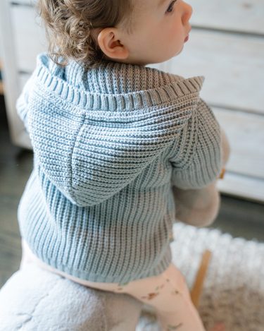 Image shows baby girl wearing pima cotton knit hoody in pearl blue.