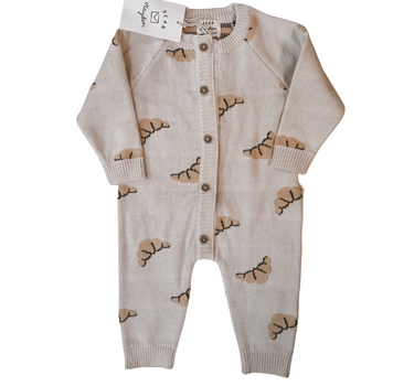 Flat lay image on white background of organic cotton knit croissant patterned romper with Magnetic Button closures.