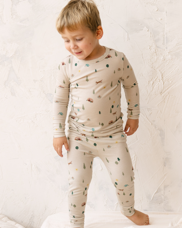 Image shows toddler boy wearing modal pajama set in camping print.
