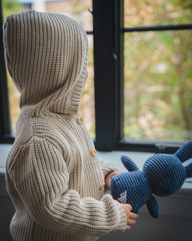 Image shows toddler boy wearing pima cotton knit waffle hoody in oatmeal.