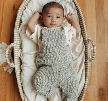 Baby boy in 100% organic cotton knit gray melange overalls with wood buttons for customizable fit. .
