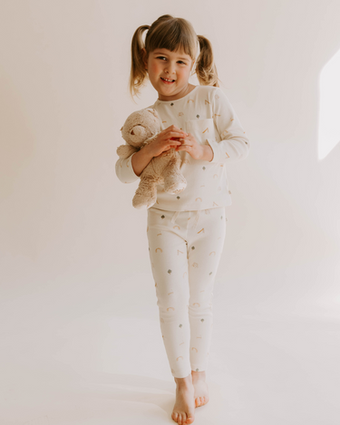 Image of little girl wearing organic cotton soft long sleeve tee in playground print with adorable pocket.