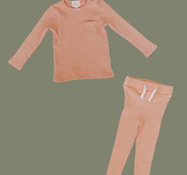 Flat lay image of organic cotton rib two piece set in strawberries and cream color. Set includes a long sleeve top with Magnetic Buttons at the neck in sizes through 12-18 months as well as leggings with a faux drawstring.