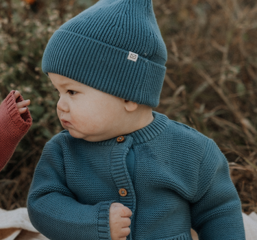 baby boy wearing organic cotton knit beanie in bluestone color