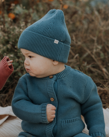 baby boy wearing organic cotton knit beanie in bluestone color