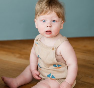 Baby wearing romper with sail boat print