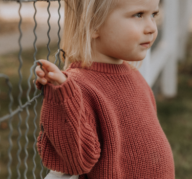 image of toddler girl wearing Dear Hayden organic cotton chunky knit set in rosewood pink