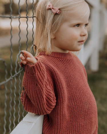 image of toddler girl wearing Dear Hayden organic cotton chunky knit set in rosewood pink