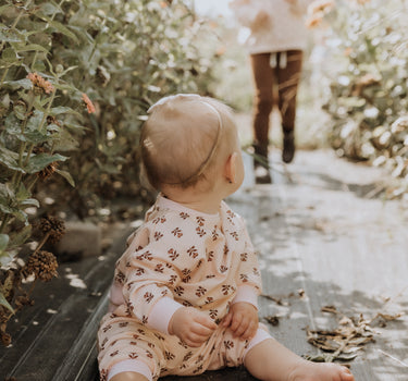 baby girl wearing organic cotton fleece joggers in light pink with rose floral pattern