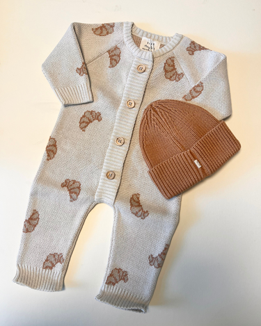 Image shows bundle with organic cotton knit croissant romper and organic cotton knit beanie in acorn.