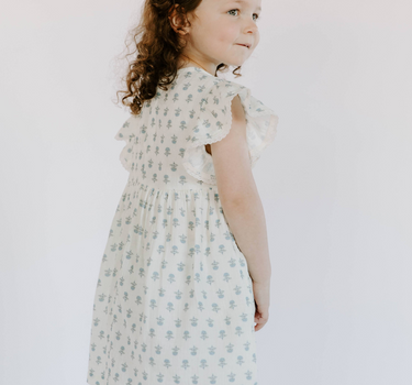 Little girl wearing cotton muslin flutter sleeve dress in cheerful floral