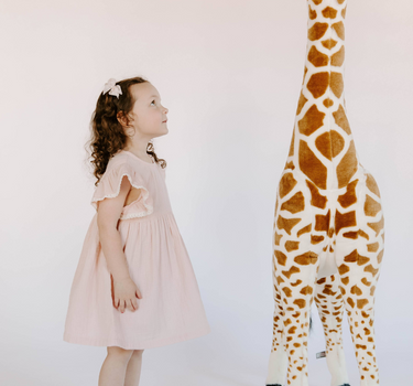 Little girl wearing cotton muslin flutter sleeve dress in orchid pink