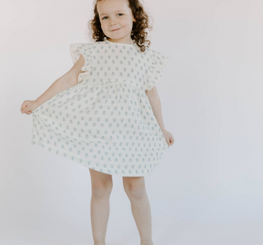 Little girl wearing cotton muslin flutter sleeve dress in cheerful floral