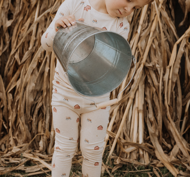 child wearing modal pajama set in light beige color with farm print