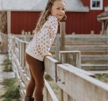 Little girl wearing organic cotton modal leggings in cappuccino. 