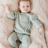 Picture shows baby girl wearing organic cotton modal rib long sleeve tee in jade color with Magnetic Buttons at the neck.