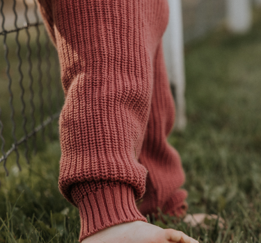 image of toddler girl wearing Dear Hayden organic cotton chunky knit set in rosewood pink