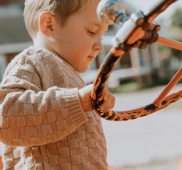 image of little boy wearing Dear Hayden organic cotton basket weave sweater in taupe