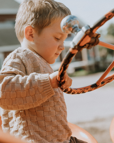 image of little boy wearing Dear Hayden organic cotton basket weave sweater in taupe