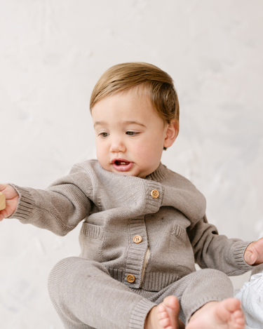 image shows baby boy wearing merino wool baby cardigan in heather brown