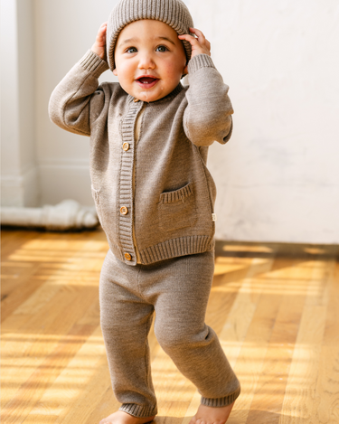 image shows baby boy wearing merino wool baby cardigan in heather brown