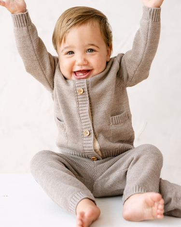 image shows baby boy wearing merino wool baby cardigan in heather brown