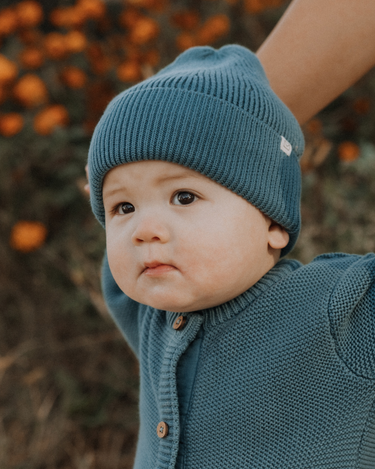 baby boy wearing organic cotton knit beanie in bluestone color