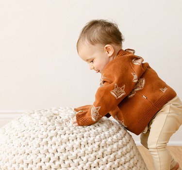 Image shows baby boy wearing organic cotton knit sweater with fox jacquard pattern in mocha. 