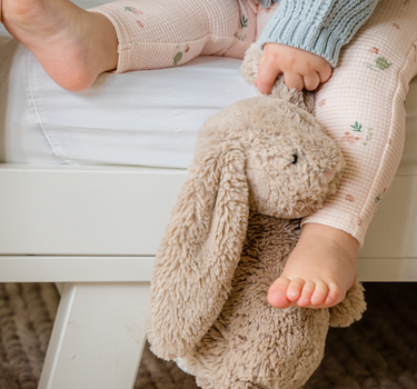 Image shows baby girl wearing organic cotton waffle leggings in bird print. 