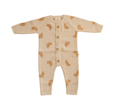 Flat lay photo of organic cotton knit romper with croissant pattern and Magnetic Buttons from neck to crotch for easy changing.