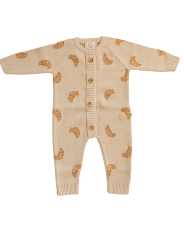 Flat lay photo of organic cotton knit romper with croissant pattern and Magnetic Buttons from neck to crotch for easy changing.