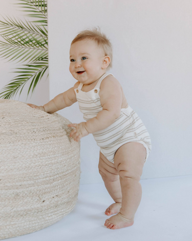 Image shows front of baby girl wearing organic cotton stripe knit romper in mushroom beige.