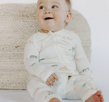 Image shows baby girl wearing modal convertible footy pajamas in zoo print.