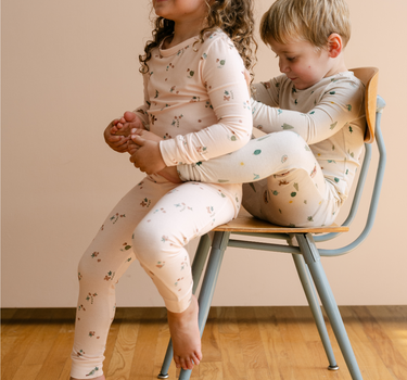 Image shows little girl wearing modal pajama set in birds print. 