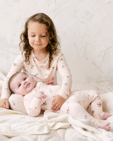 Image shows little girl wearing modal pajama set in birds print. 