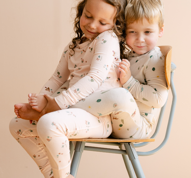 Image shows little girl wearing modal pajama set in birds print. 